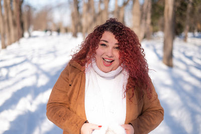 Portrait of young woman standing on snow