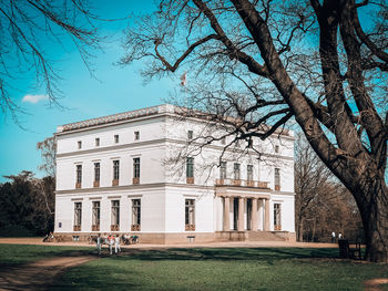 Built structure with bare tree in foreground