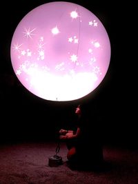 Woman holding illuminated light in the dark