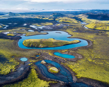 High angle view of lake amidst landscape against sky