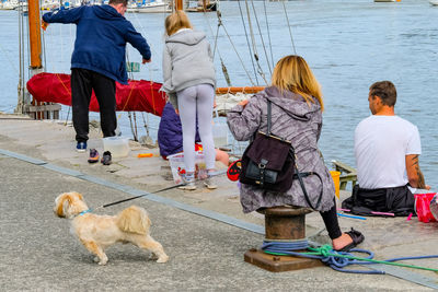 People with dog walking on street