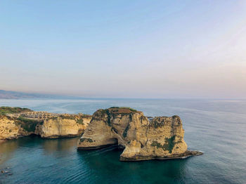 Scenic view of rock formation in sea against sky