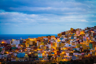 Cityscape by sea against sky