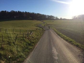 Road amidst field against sky