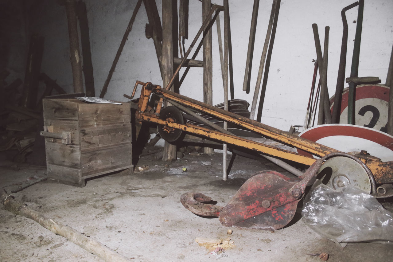 OLD RUSTY MACHINE PART BY ABANDONED BUILDING