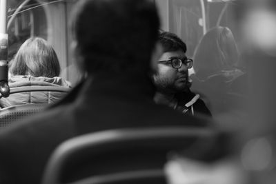 Young man looking through window while sitting in train