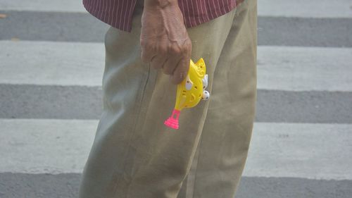 Close-up mid section of a man holding a toy