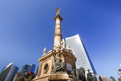 Low angle view of statue of building against blue sky