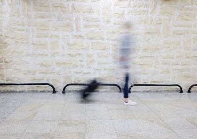 Blurred image of woman walking on wall in city