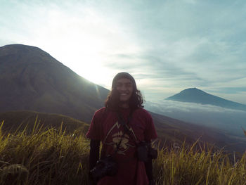 Woman standing on mountain against sky