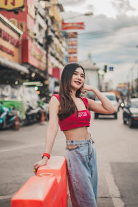 Young woman standing on street in city