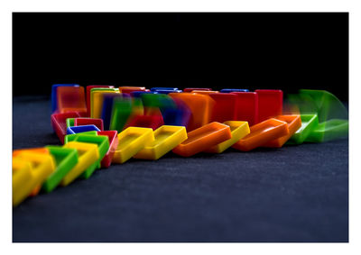 Close-up of multi colored pencils in row against black background