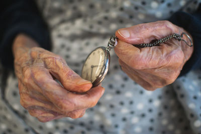 Close-up of senior woman holding pocket watch