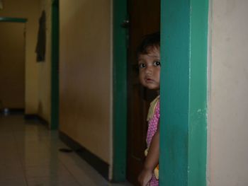 Portrait of innocent girl standing at corridor