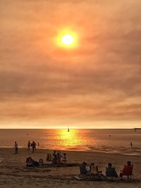 People at beach during sunset