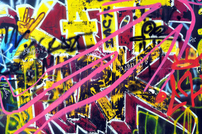 Full frame shot of multi colored graffiti on metal