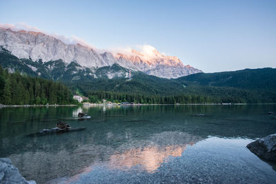 Scenic view of lake by mountains against sky