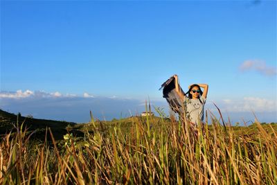 Woman standing on field against sky