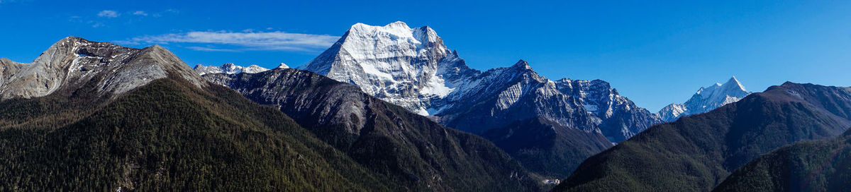 Panoramic view of snowcapped mountains against blue sky