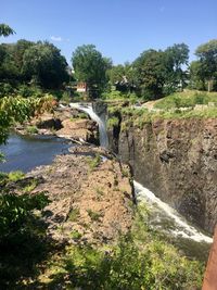 Scenic view of waterfall in forest against clear sky