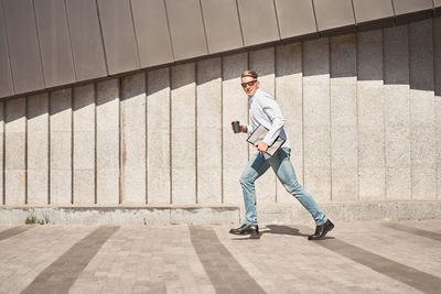 Full length of man standing against wall