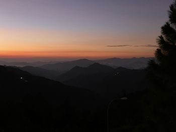 Scenic view of silhouette mountains against sky at sunset