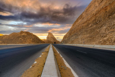 Empty road against sky during sunset