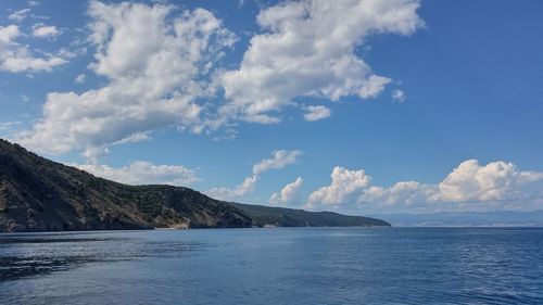 Scenic view of sea and mountains against sky