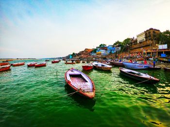 Boats moored in sea against sky