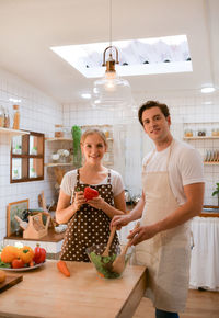 Young couple prepares cooking a breakfast in kitchen with a fun smile and happiness