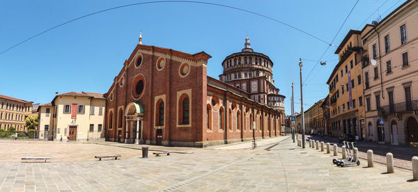 Buildings in city against clear blue sky