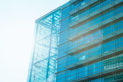 Low angle view of glass building against clear sky