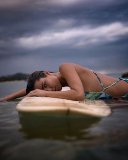 Portrait of woman lying down against sky