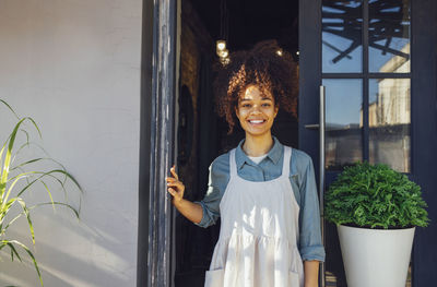 Portrait of young woman standing by window