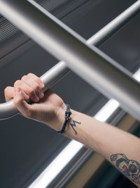 Low angle cropped hand of man with tattoo traveling in vehicle