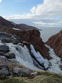Scenic view of rocks in sea against sky
