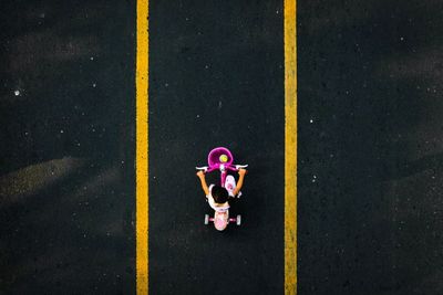 High angle view of girl riding bicycle on road