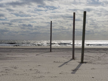 Scenic view of beach against cloudy sky