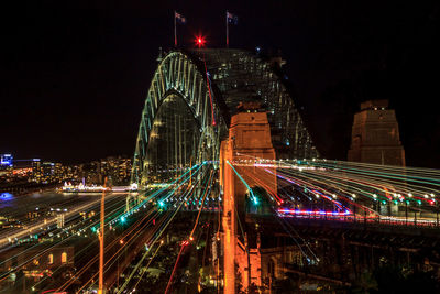 Light trails on city against sky at night