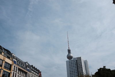 Low angle view of fernsehturm and buildings against sky