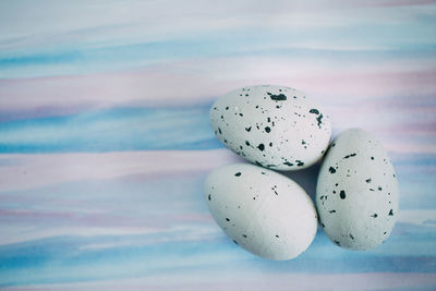 Close-up of quail eggs against colored background