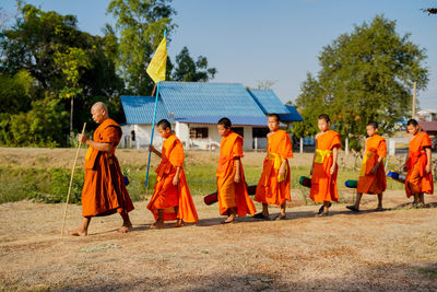 Rear view of people walking by trees