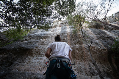 Rear view of man climbing rock