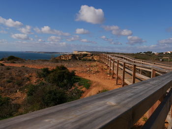 Road leading towards bridge against sky