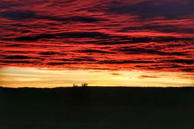 Silhouette of landscape against cloudy sky