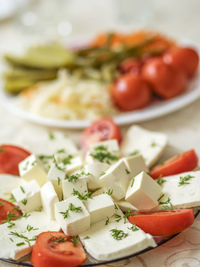 Close-up of feta cheese with tomatoes served in plate on table