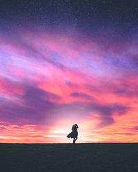 Woman walking against dramatic sky during sunset