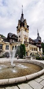 Water fountain against building in city