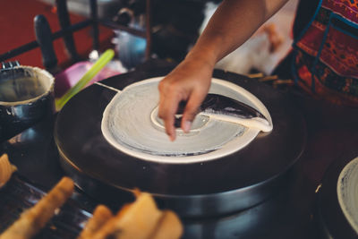 Midsection of person preparing food at market stall