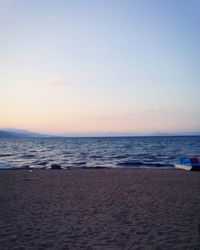 Scenic view of beach against clear sky during sunset